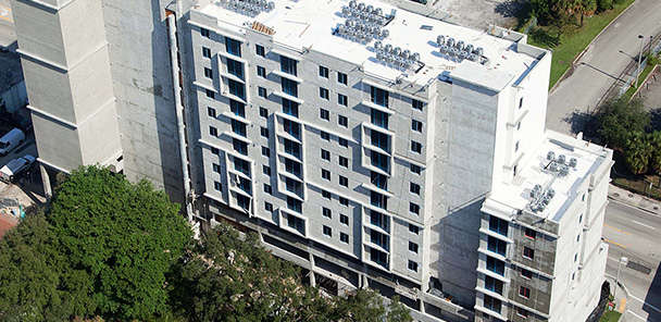 Aerial view of tall, contemporary, concrete multi-story apartment building